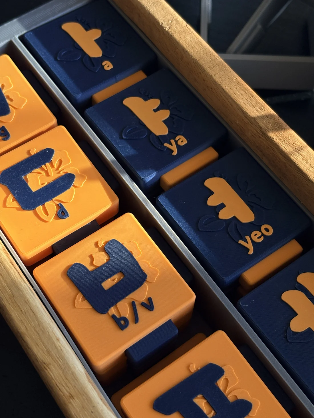 Close-up of orange and blue tiles with raised letters